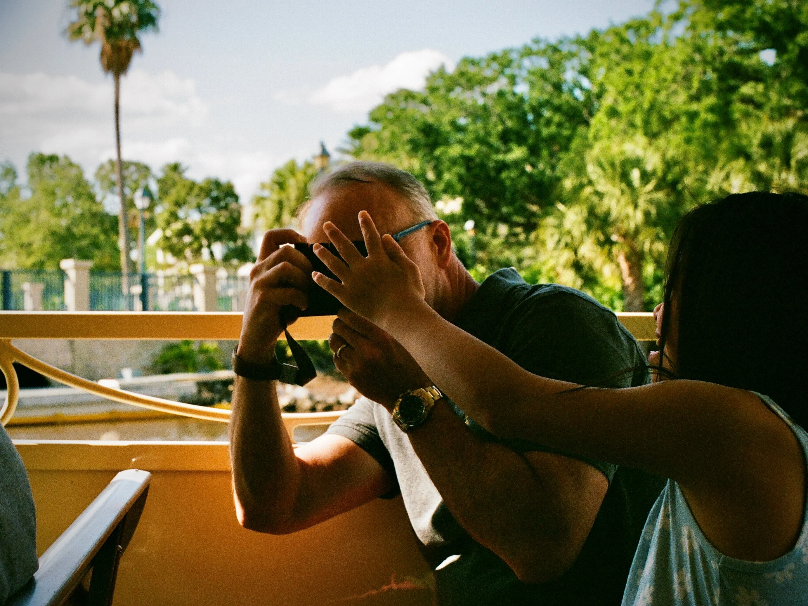 A person raising a camera at an outdoor table in Orlando
