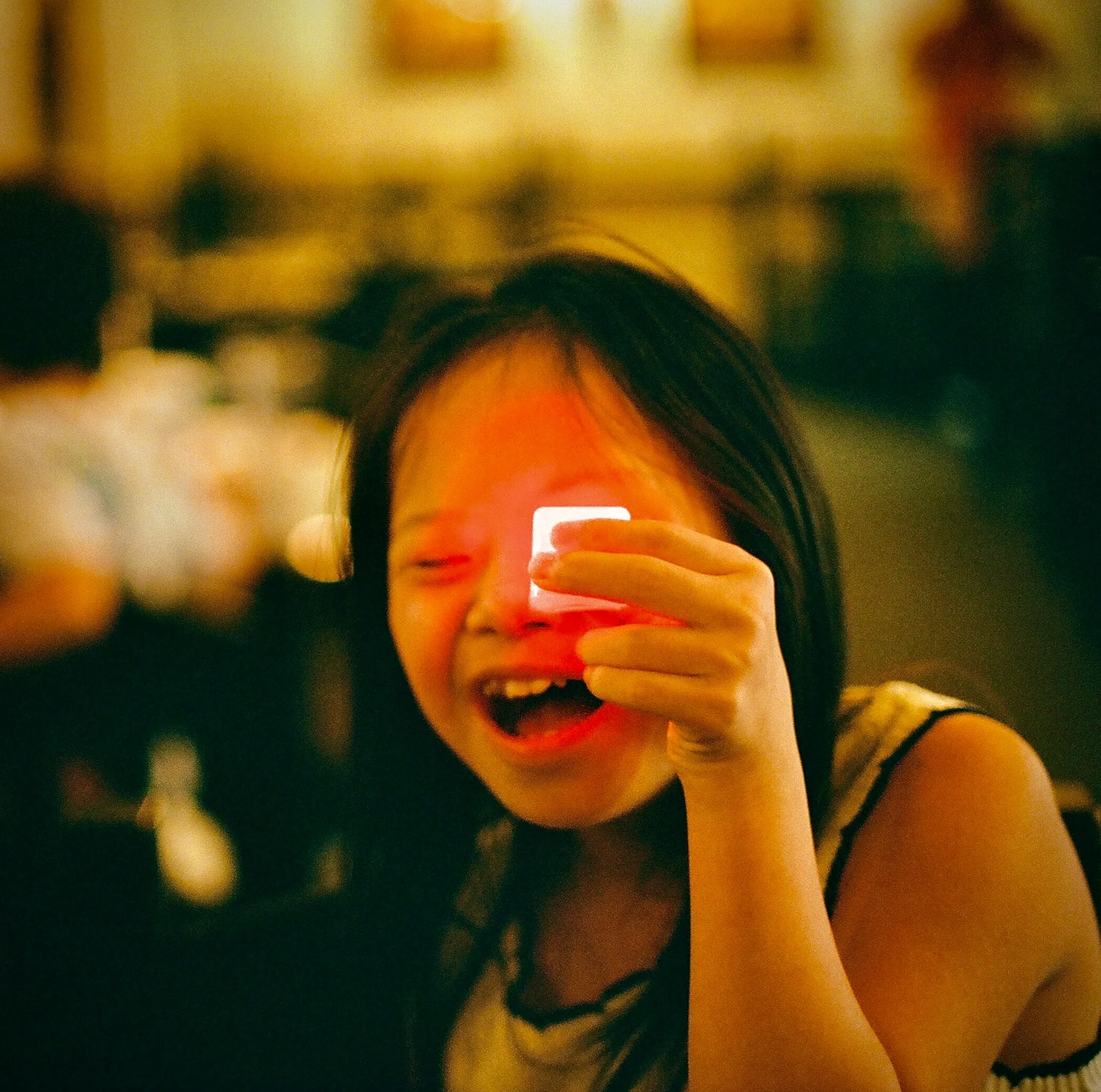 A person looking at a small object in warm indoor light in Orlando