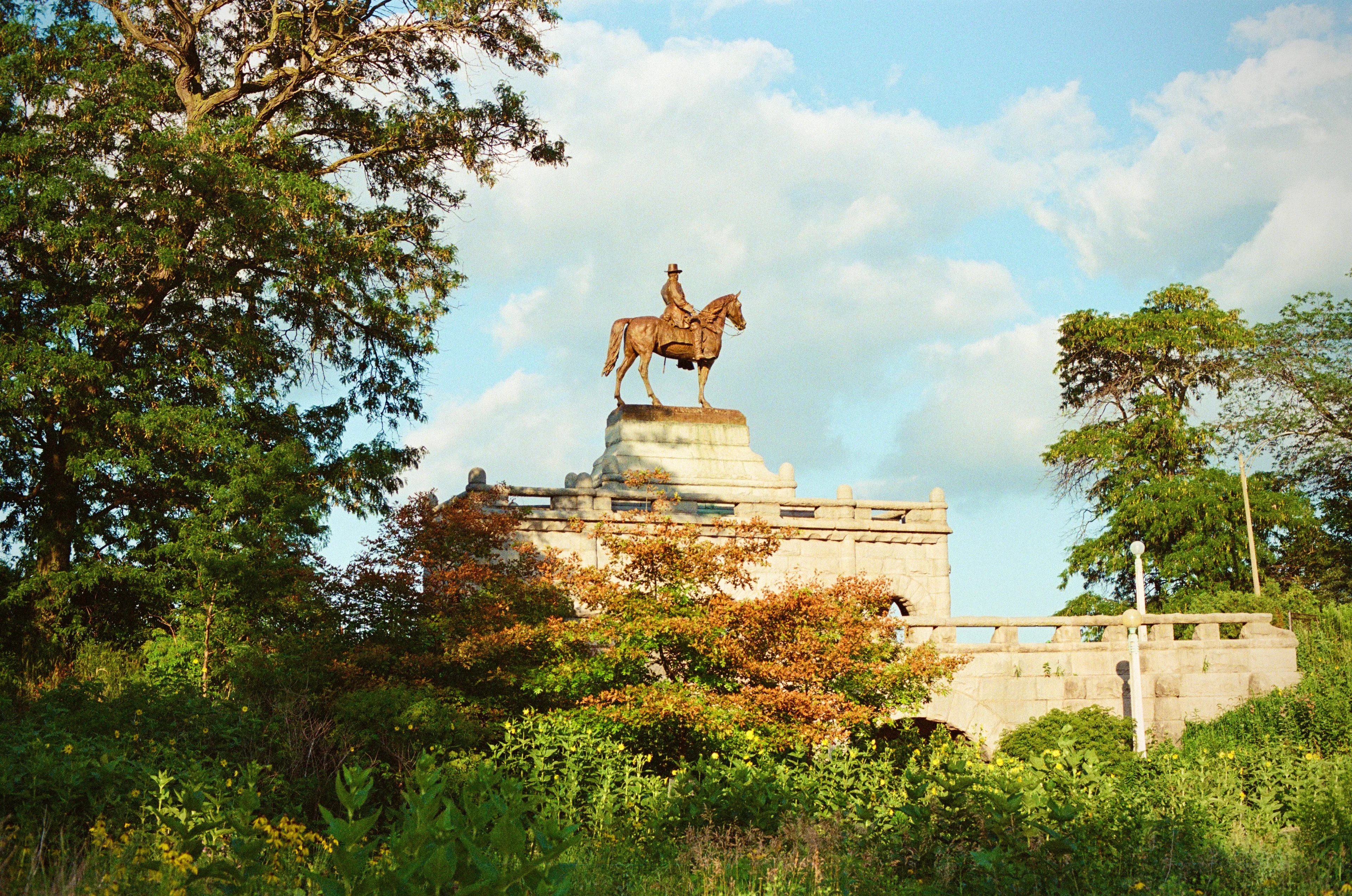 An equestrian monument framed by leafy trees in Chicago