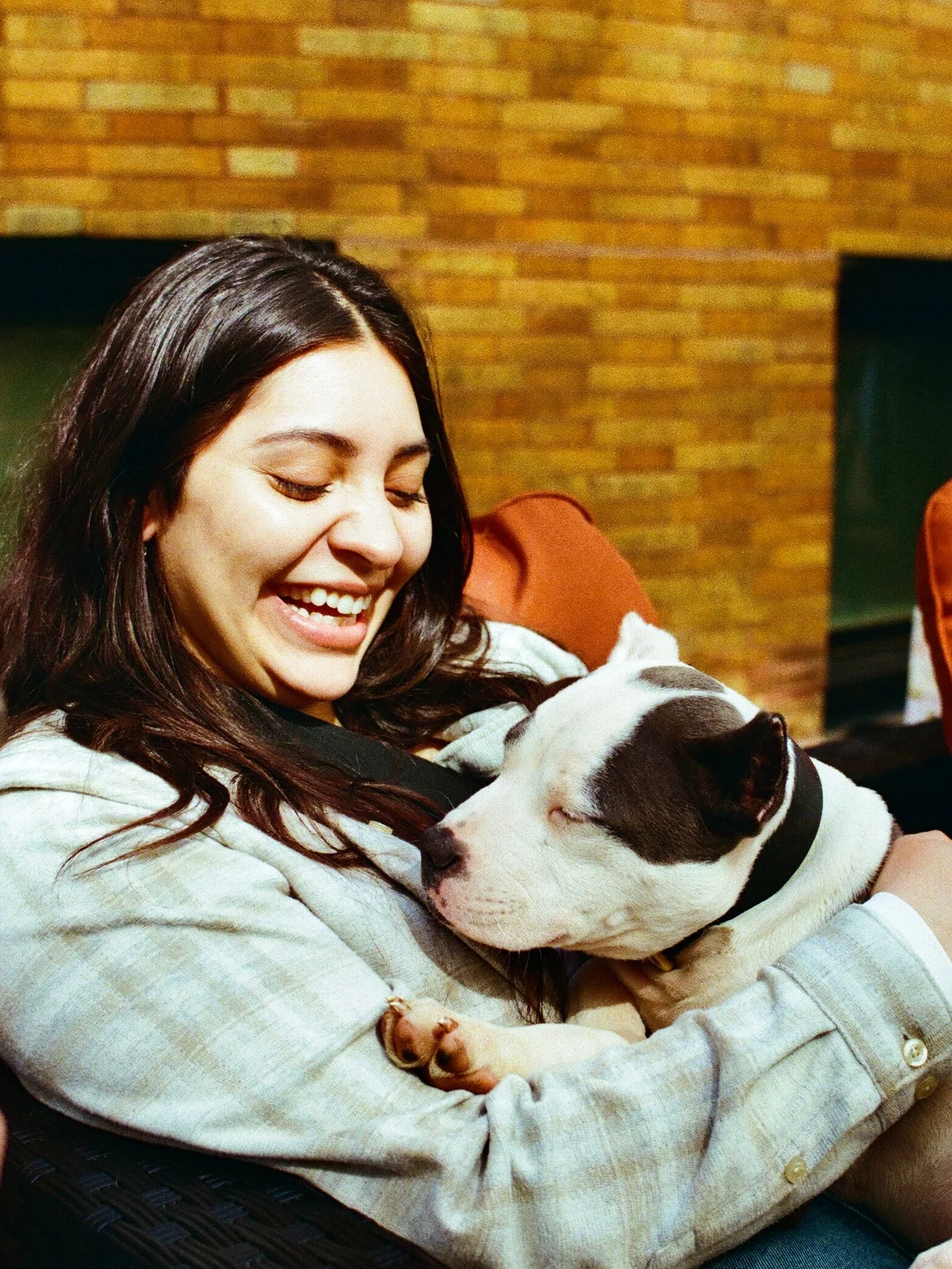 A smiling person holding a black and white cat in Chicago