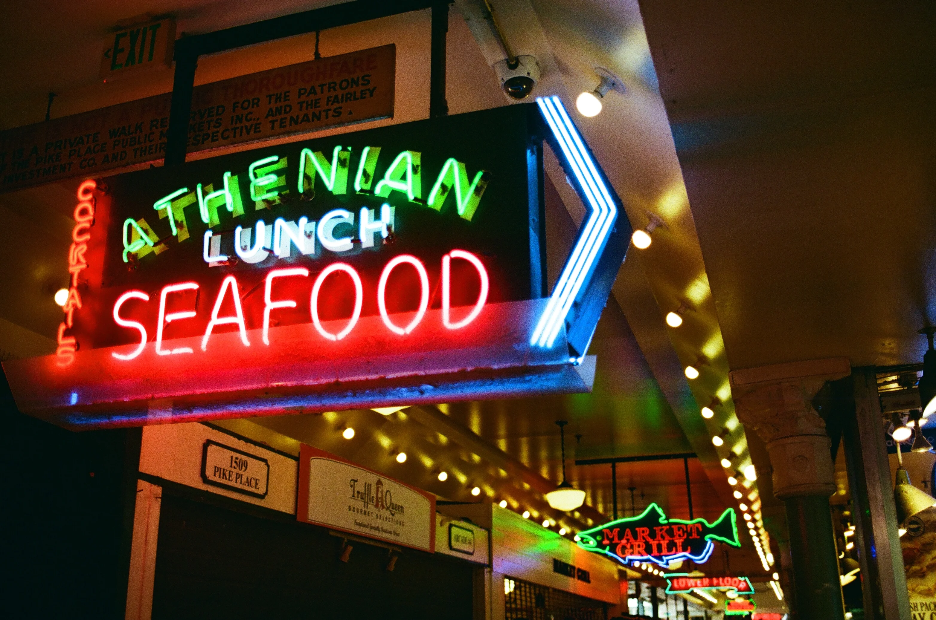 A glowing seafood sign outside a restaurant at night in Seattle
