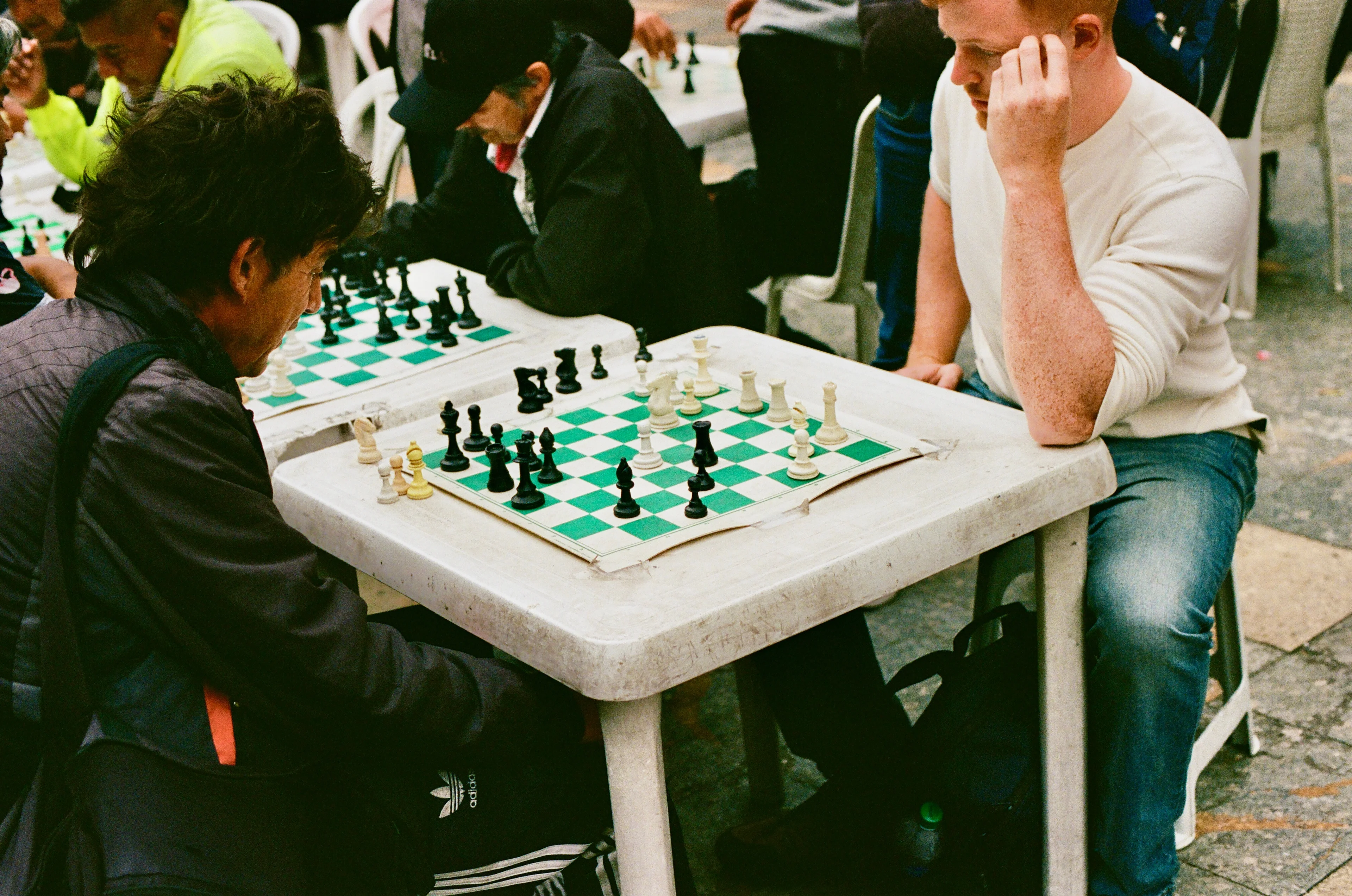 People playing chess at an outdoor table in Bogota