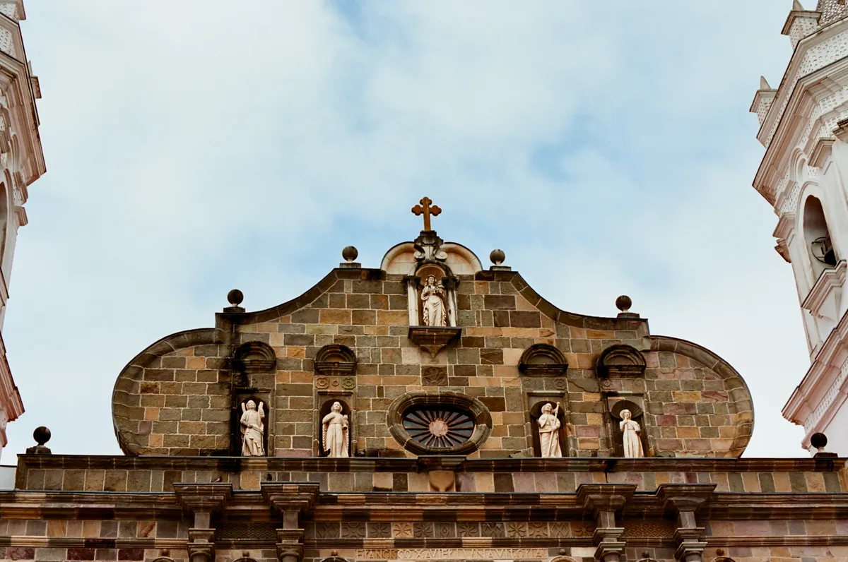 An ornate stone church facade beneath a cloudy sky in Panama City